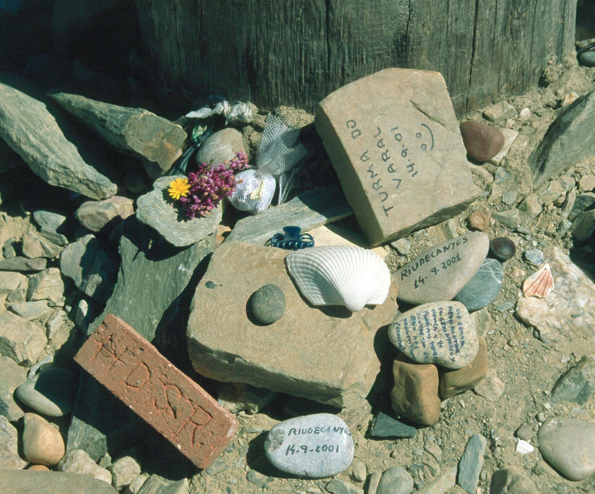 Scallop shells and pilgrims' stones laid at the foot of the cross