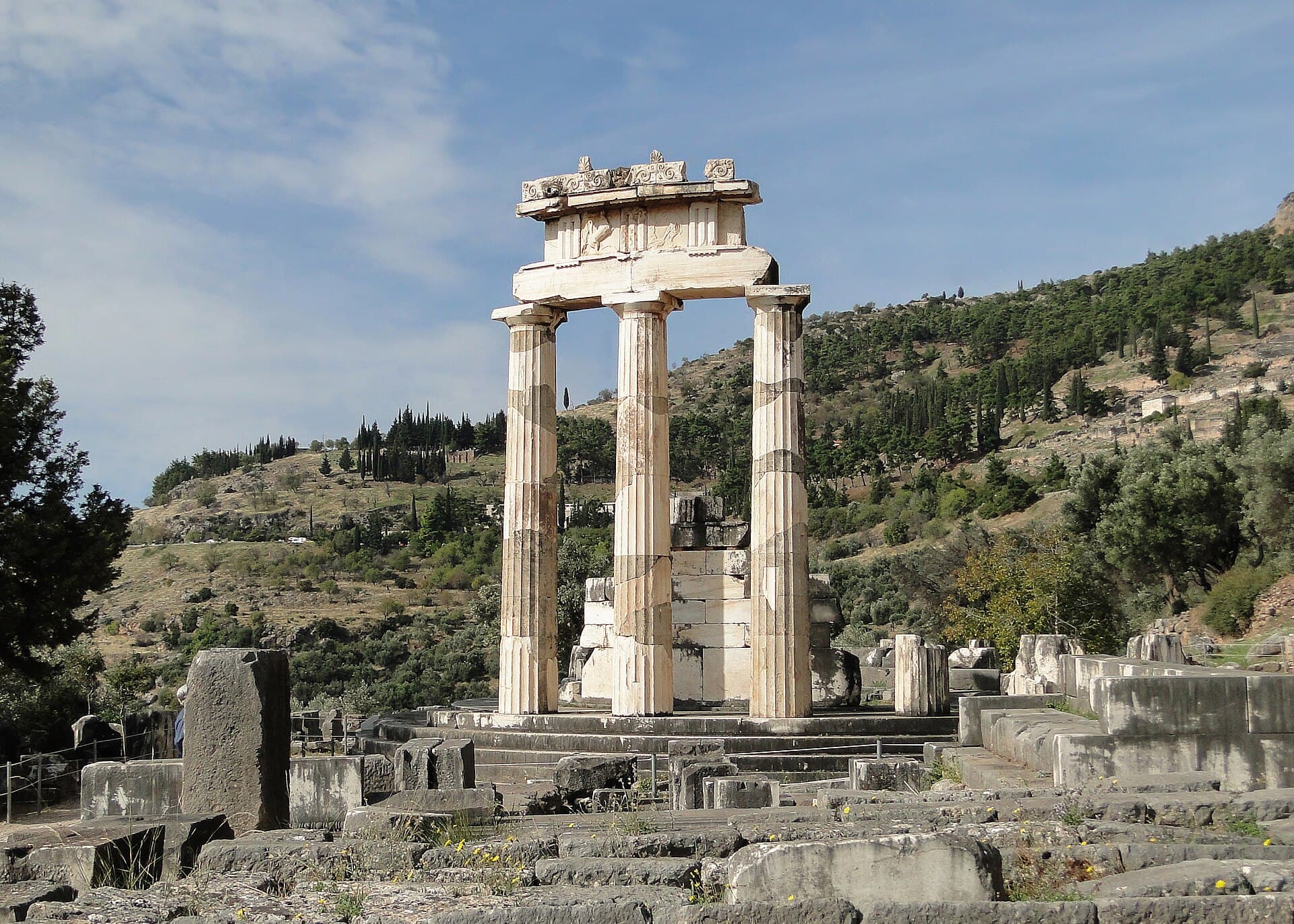 The circular temple (tholos) of Athena Pronaia against the green mountainside
