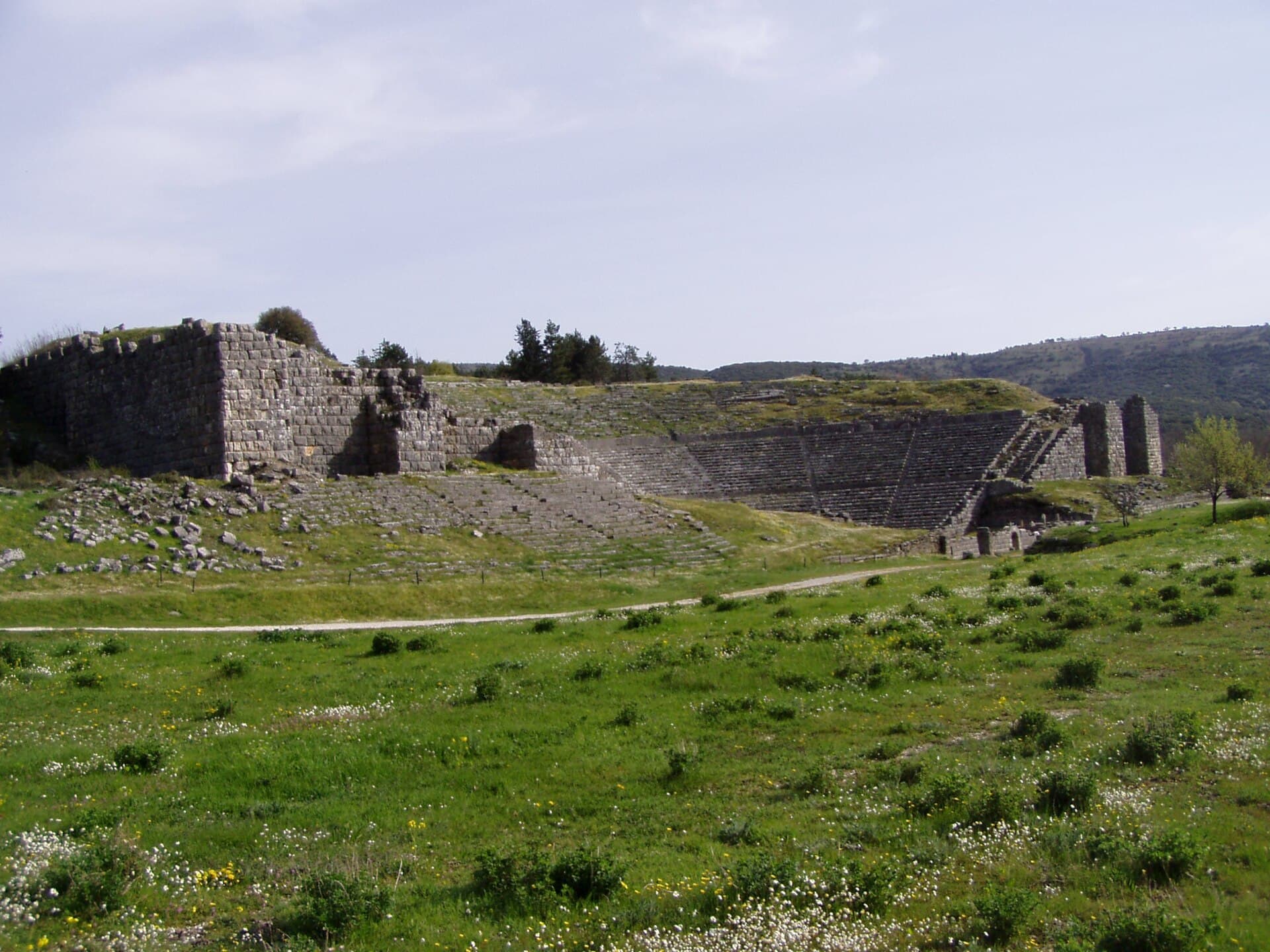 A wide view of the theatre and sanctuary of Dodona set in green fields