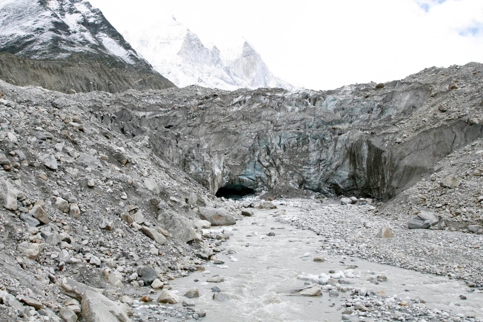 Gaumukh — the river emerging from the ice-cave snout of the glacier, snow peaks rising behind