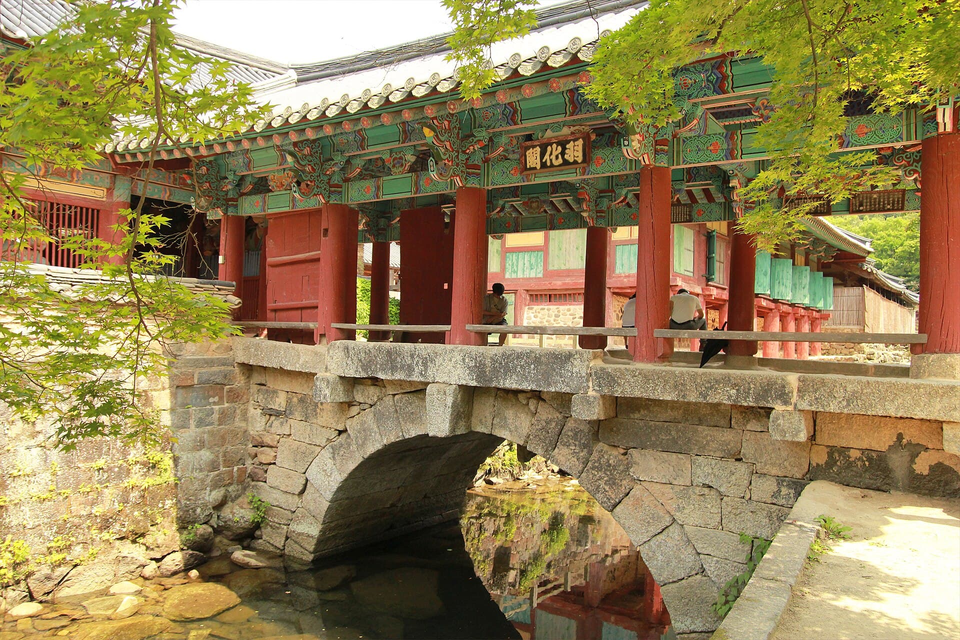 The Uhwagak covered bridge resting on a stone arch over the stream