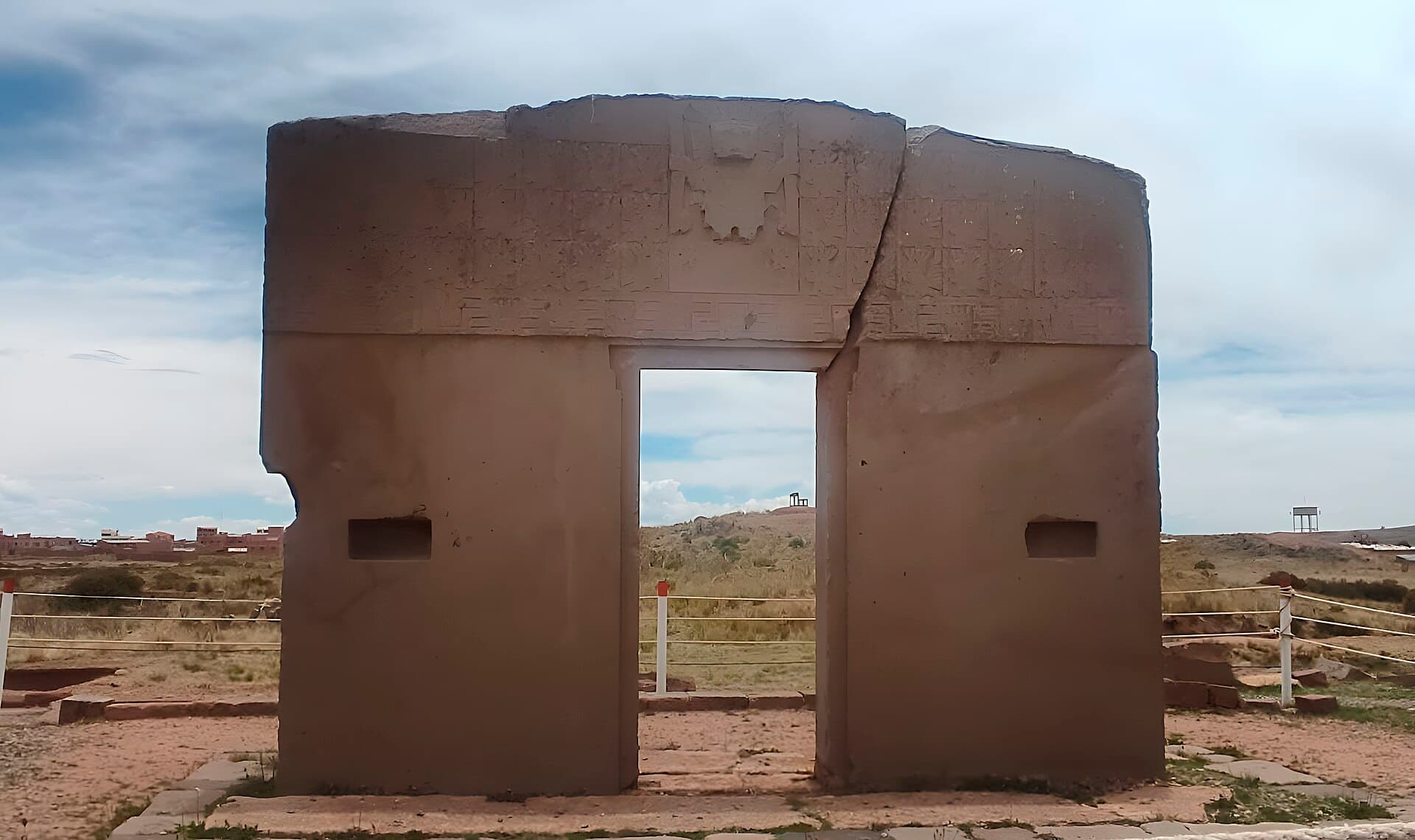 The Gate of the Sun standing alone toward the sky, a staff-bearing god carved on its lintel