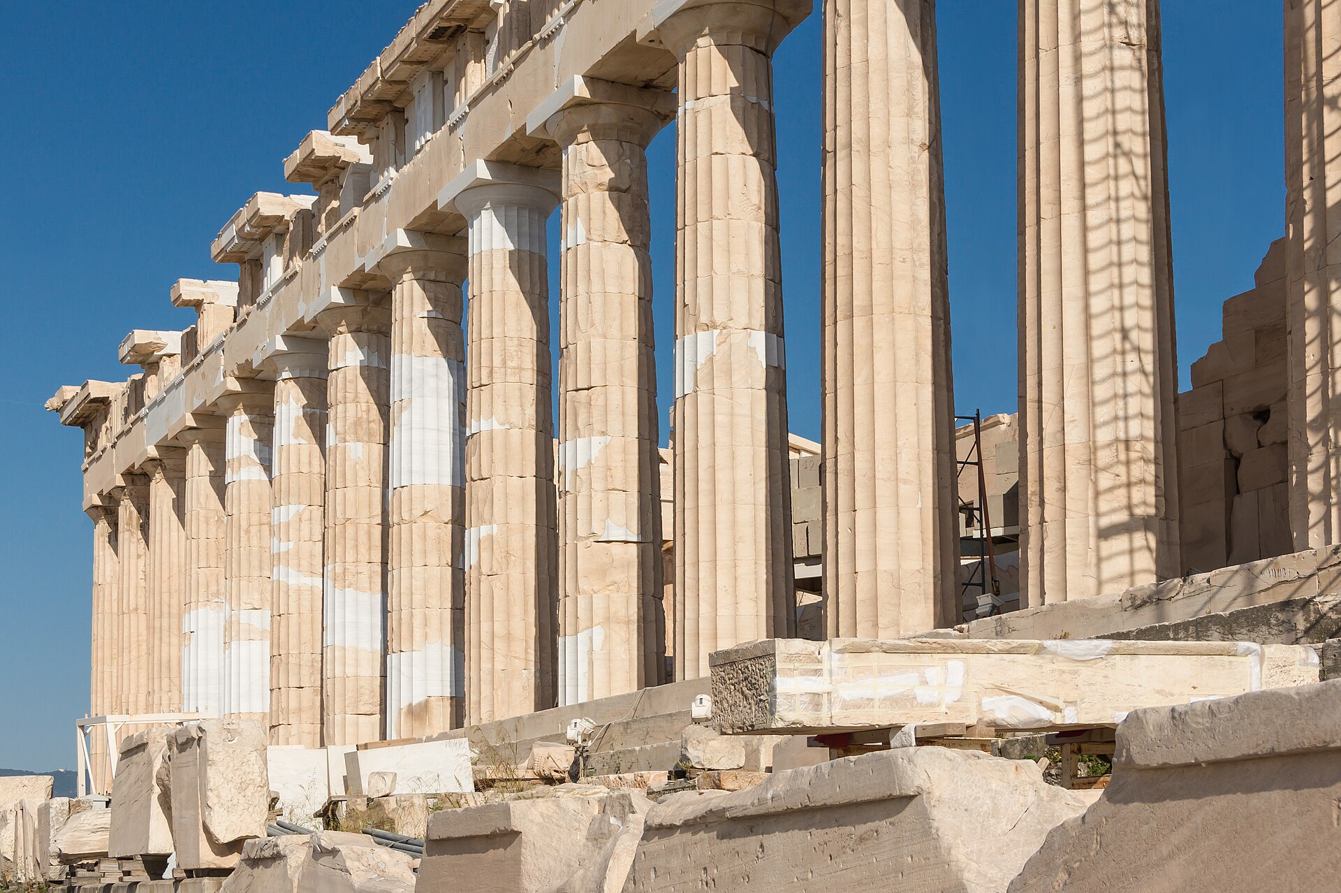 The Doric marble columns of the Parthenon against a blue sky