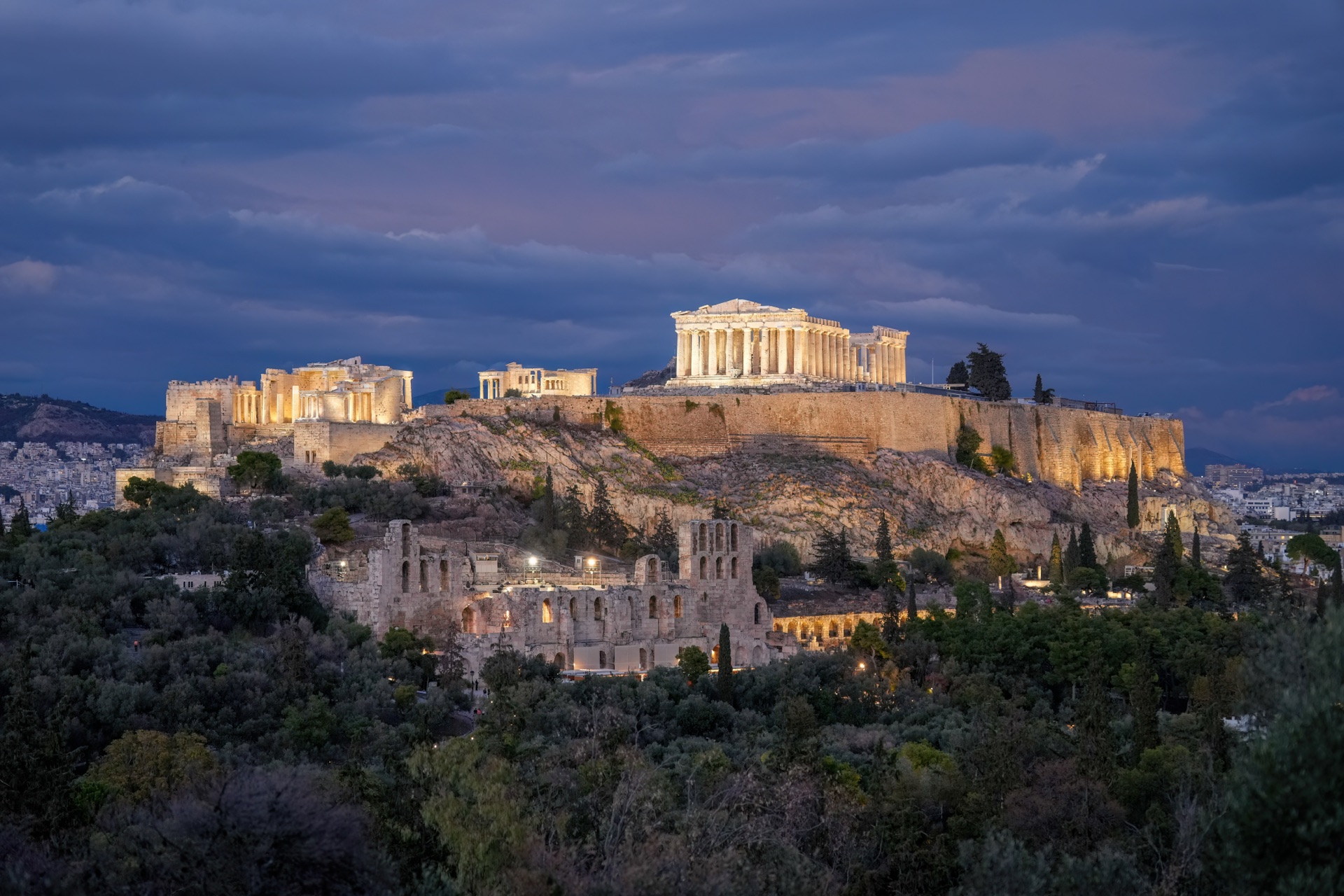 The whole Acropolis floodlit at dusk — the Parthenon and the Odeon of Herodes Atticus