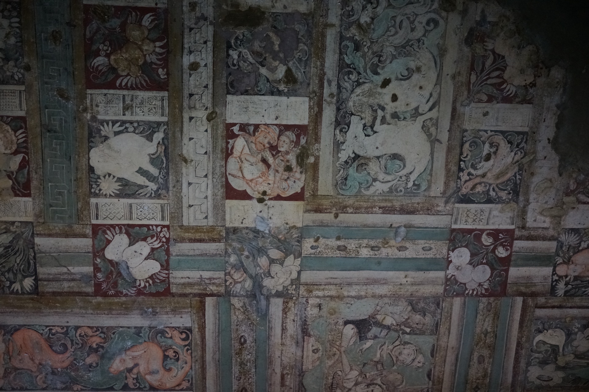 A vividly painted ceiling of Ajanta, dense with patterns and figures