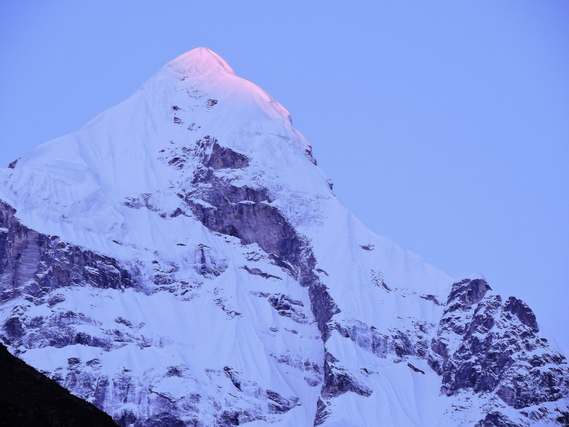 The snow pyramid of Neelkanth peak, its summit burning gold