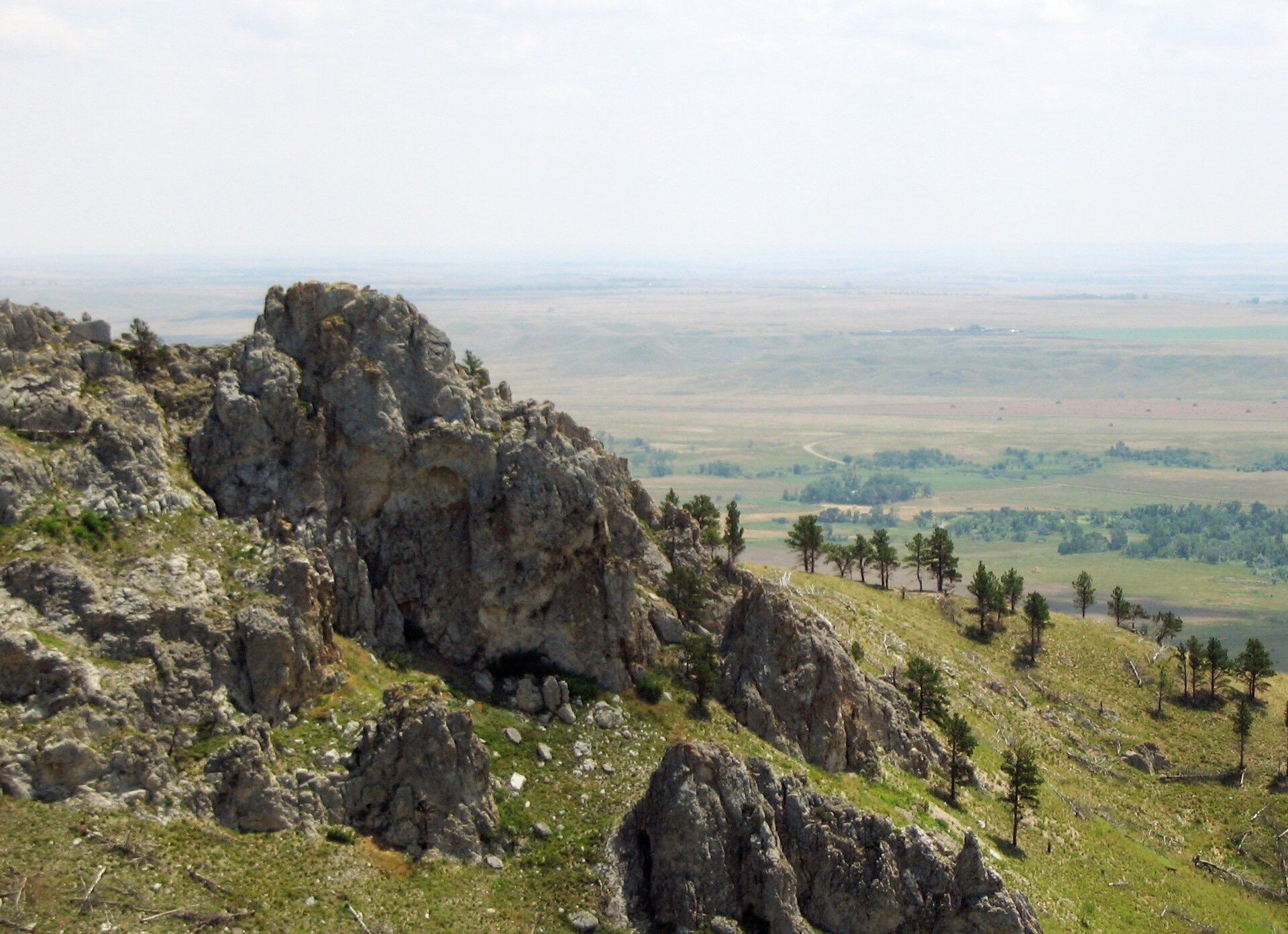 The vast plains stretching away beyond a rocky ridge on the mountain