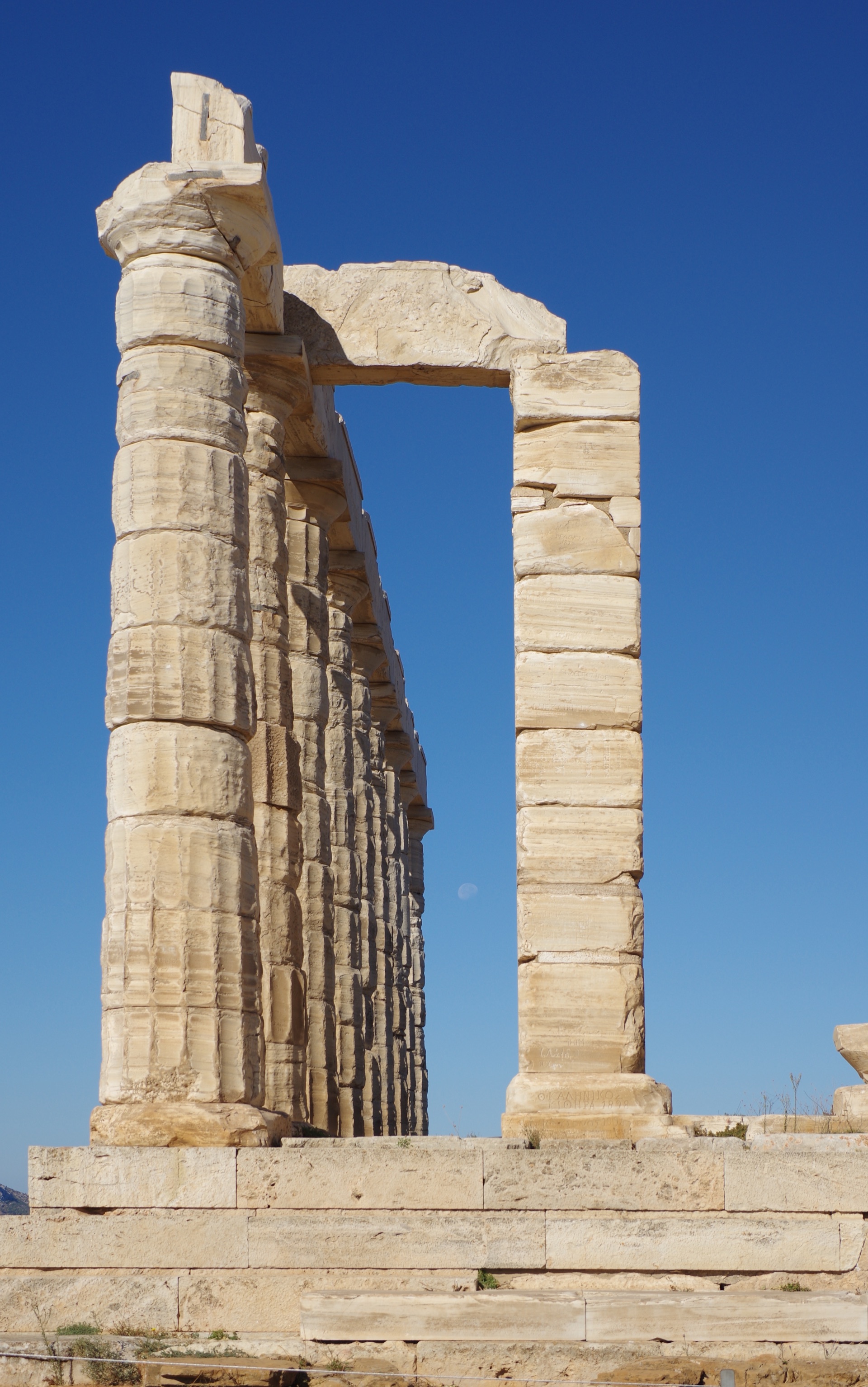The corner columns and architrave of the Temple of Poseidon framing the blue sky