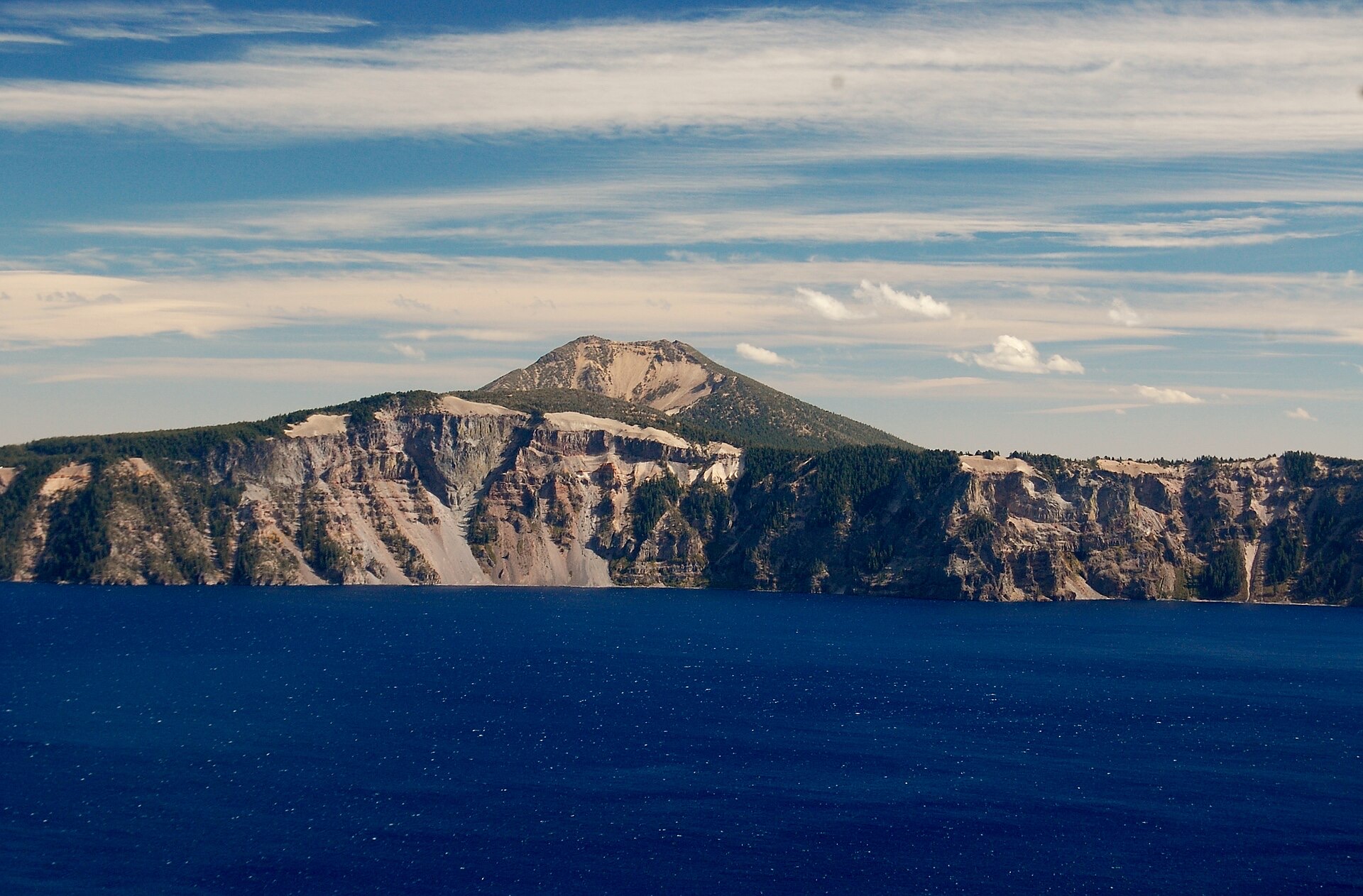 The steep caldera wall rising above the deep blue water
