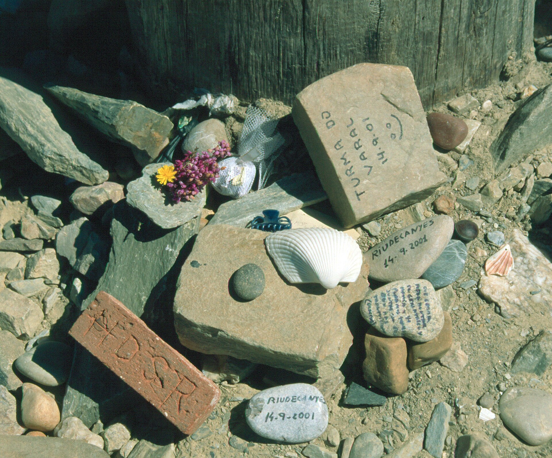 Scallop shells and pilgrims' stones laid at the foot of the cross