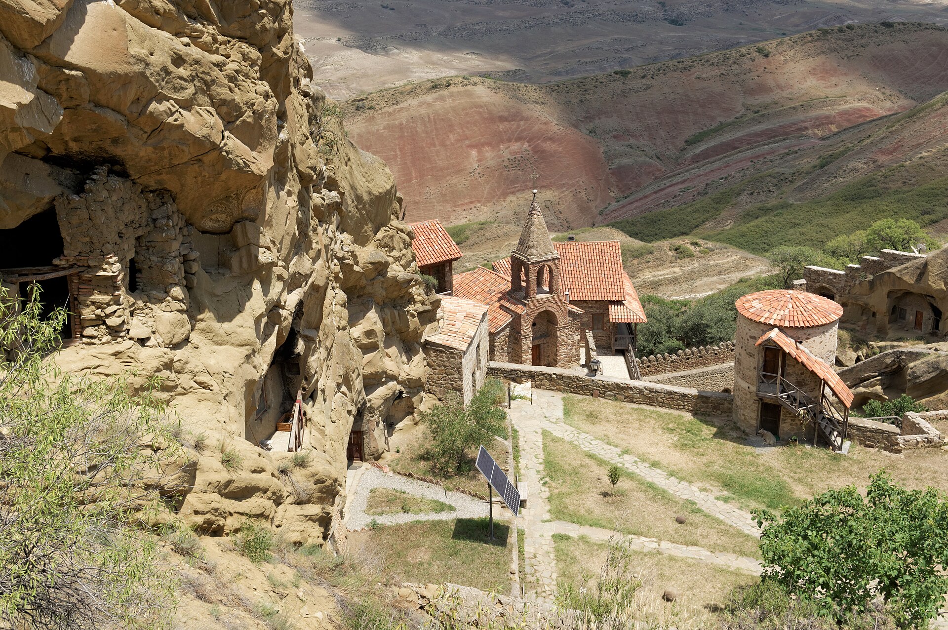 Monks' caves honeycombing the cliff beside a red-tiled bell tower