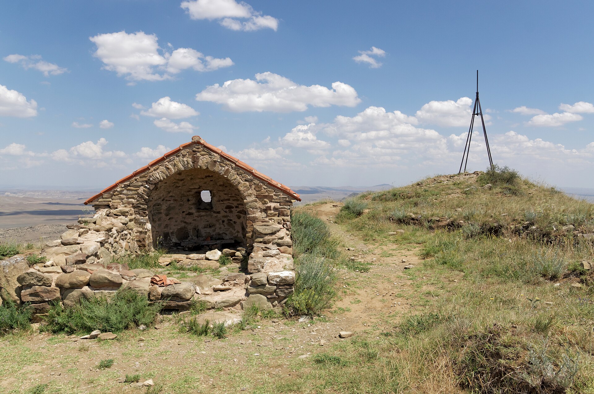 A small stone chapel left standing on a semi-desert ridge