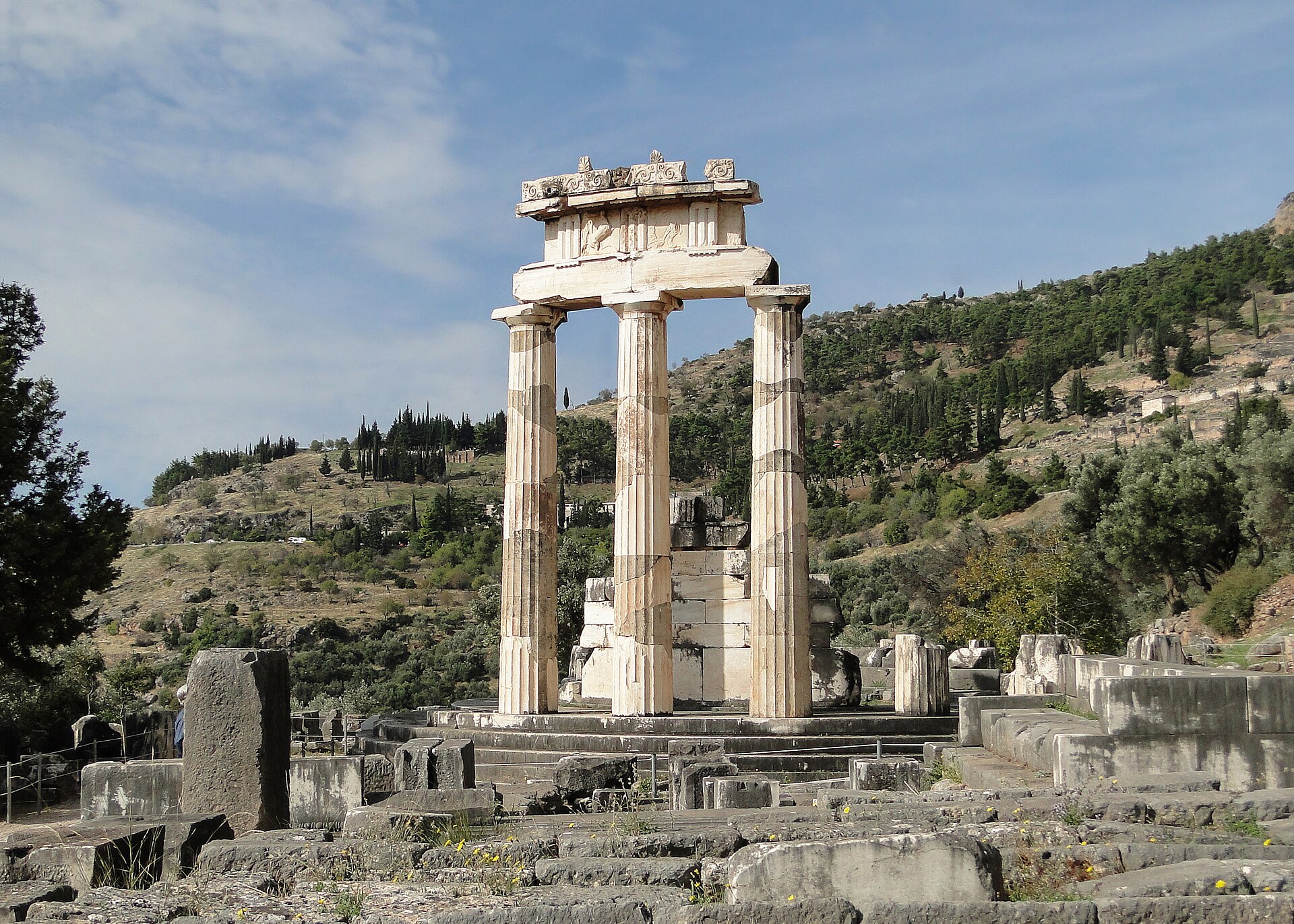 The circular temple (tholos) of Athena Pronaia against the green mountainside