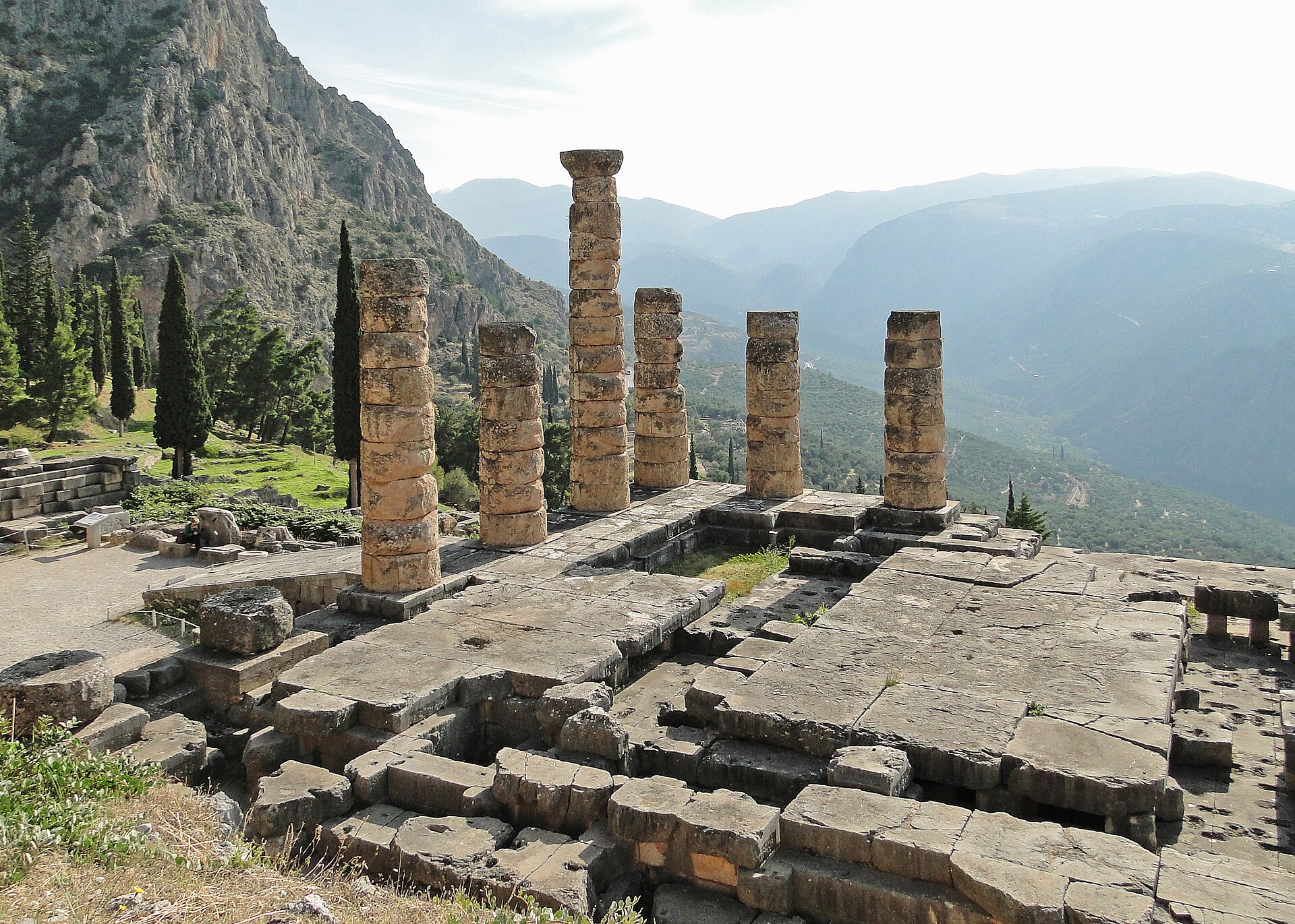Doric columns of the Temple of Apollo on the slope of Mount Parnassus, a valley opening below