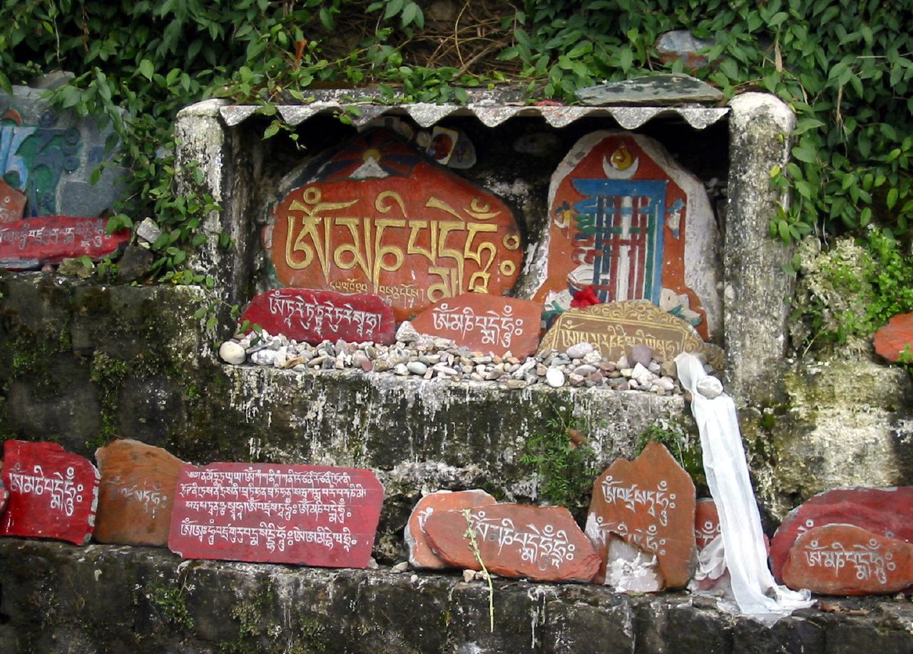 Painted mani stones stacked along the kora path of the Tsuglagkhang complex