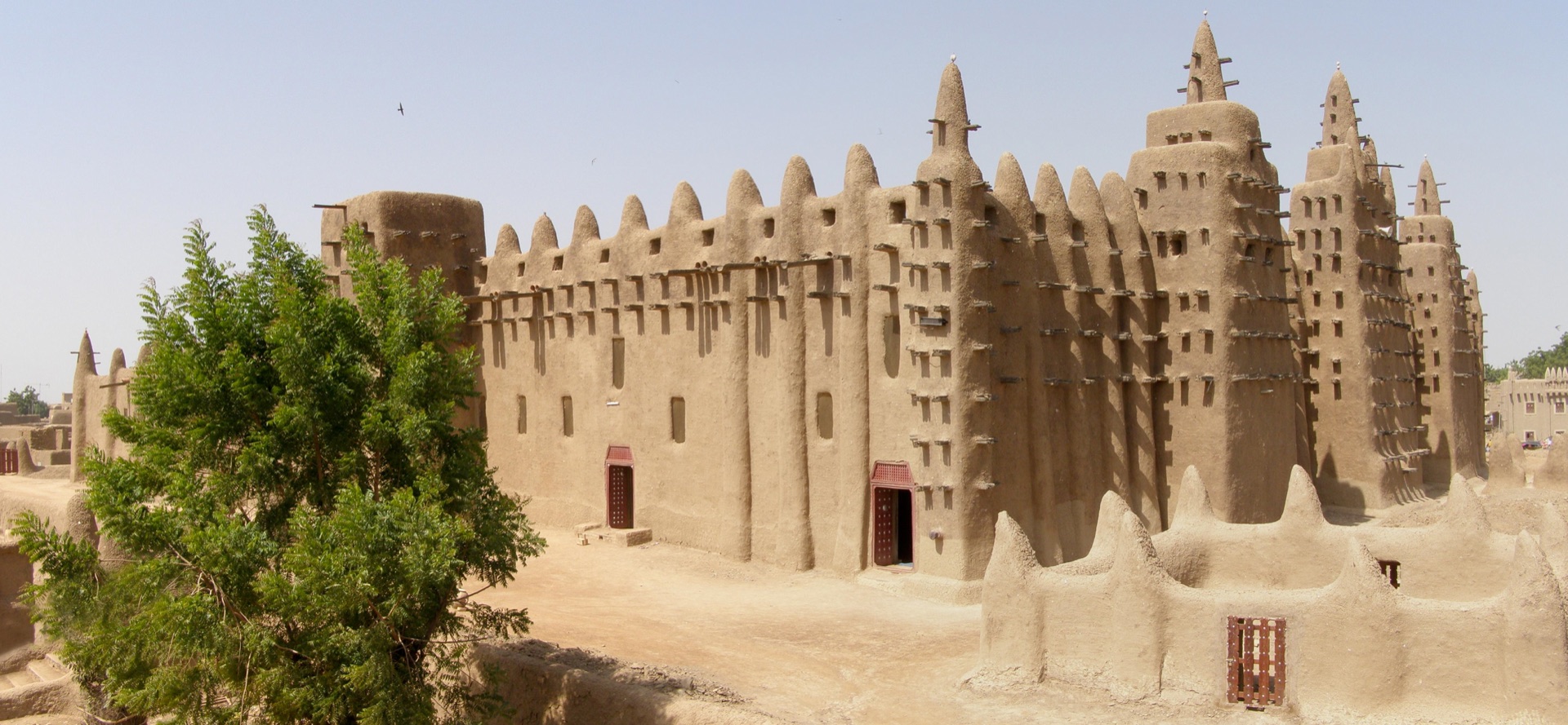 The full mud-brick mass of the Great Mosque of Djenné, its three minarets and palm-wood beams