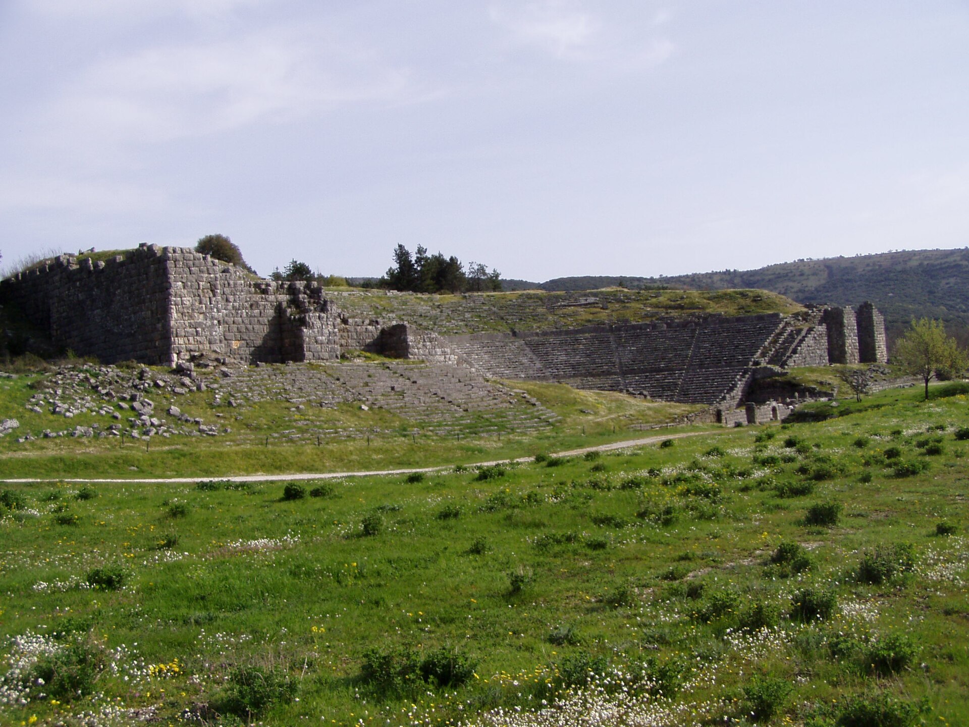 A wide view of the theatre and sanctuary of Dodona set in green fields