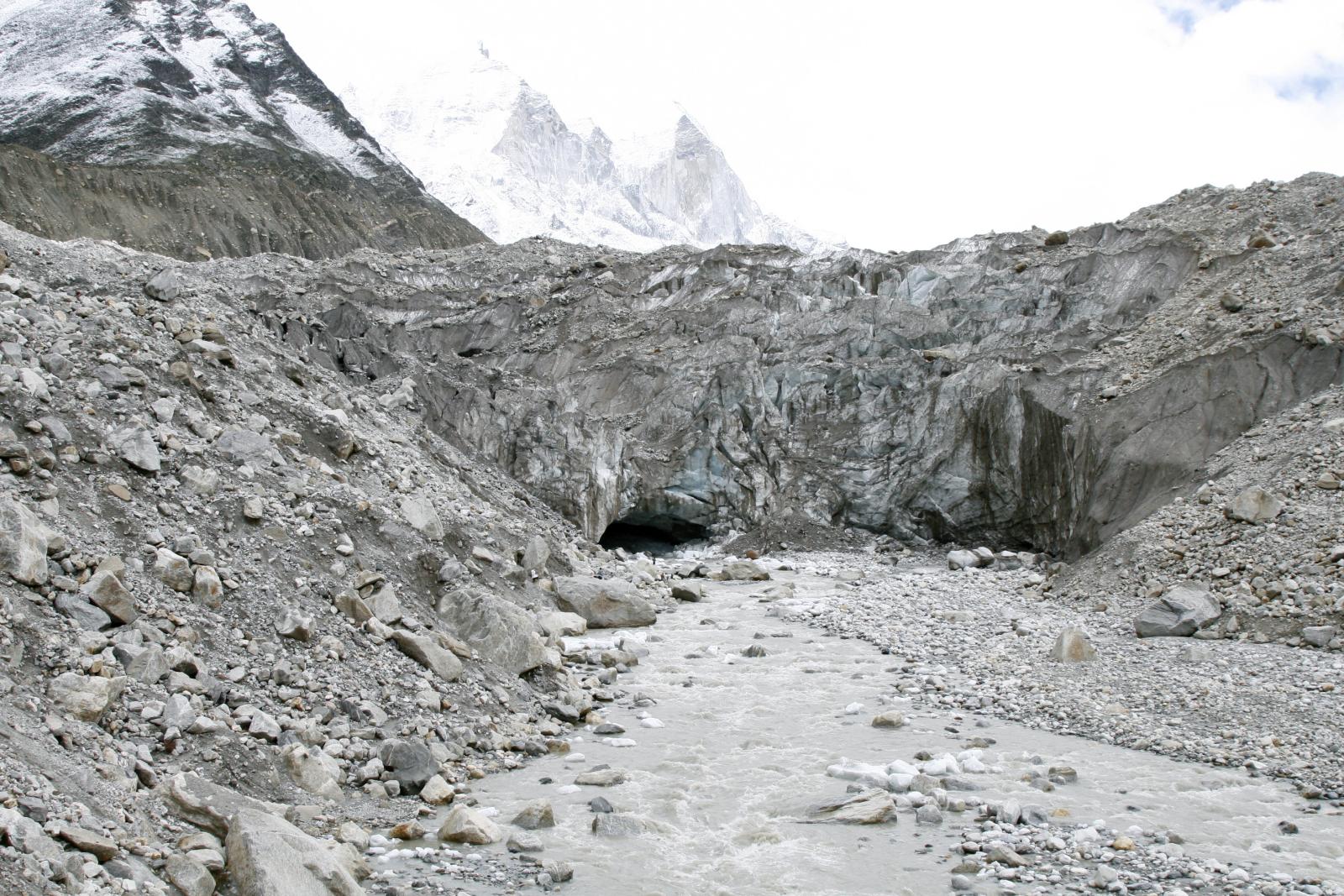 Gaumukh — the river emerging from the ice-cave snout of the glacier, snow peaks rising behind