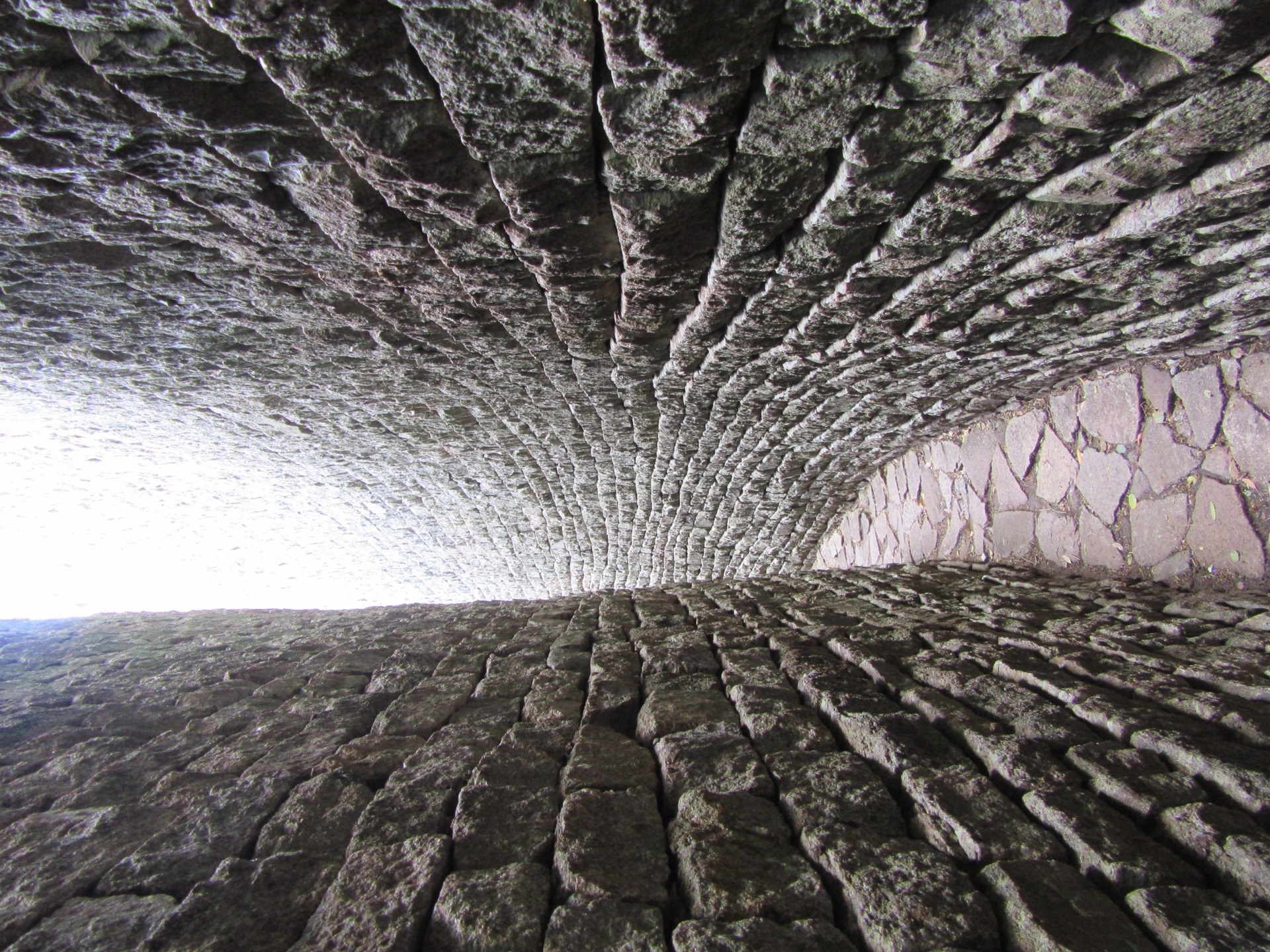 A narrow passage curving away between two mortarless granite walls