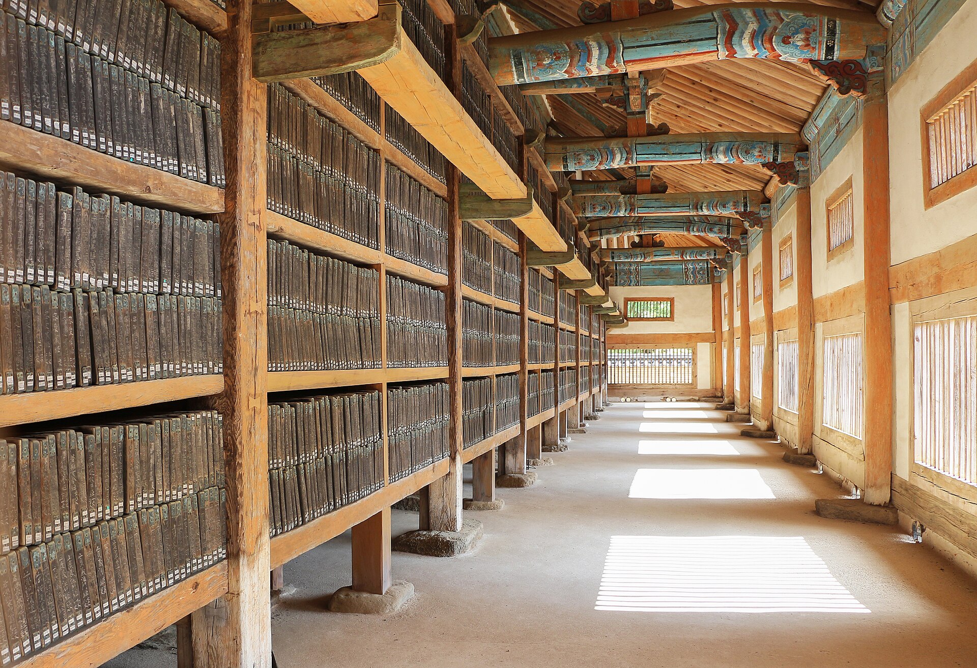 Inside the depository, light from the lattice windows falls between shelves of woodblocks