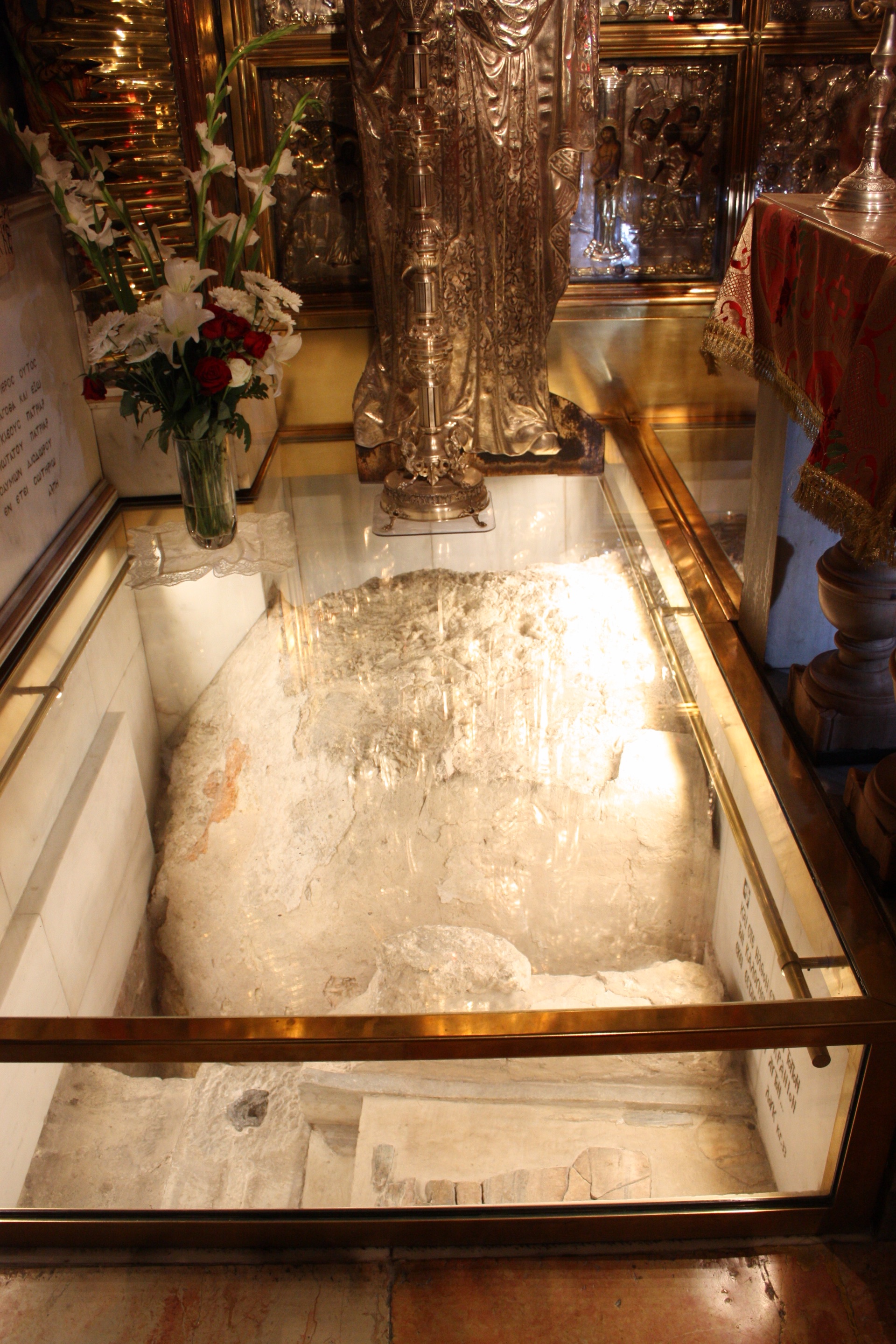 The rock of Golgotha revealed under glass beneath the Greek Orthodox altar