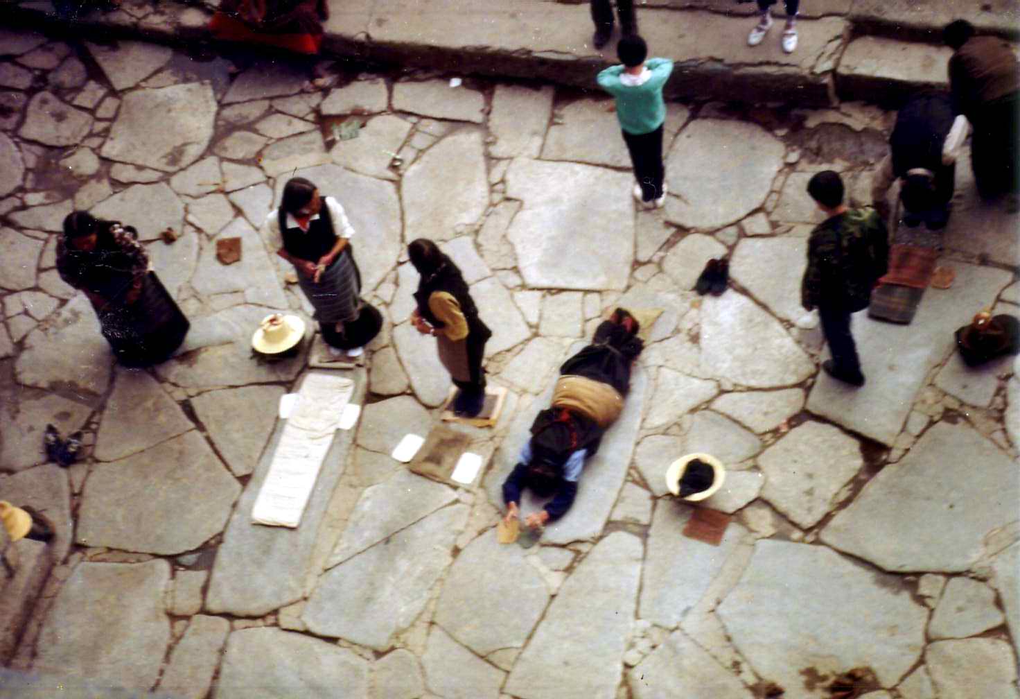 Pilgrims prostrating full-length on the worn stones before Jokhang