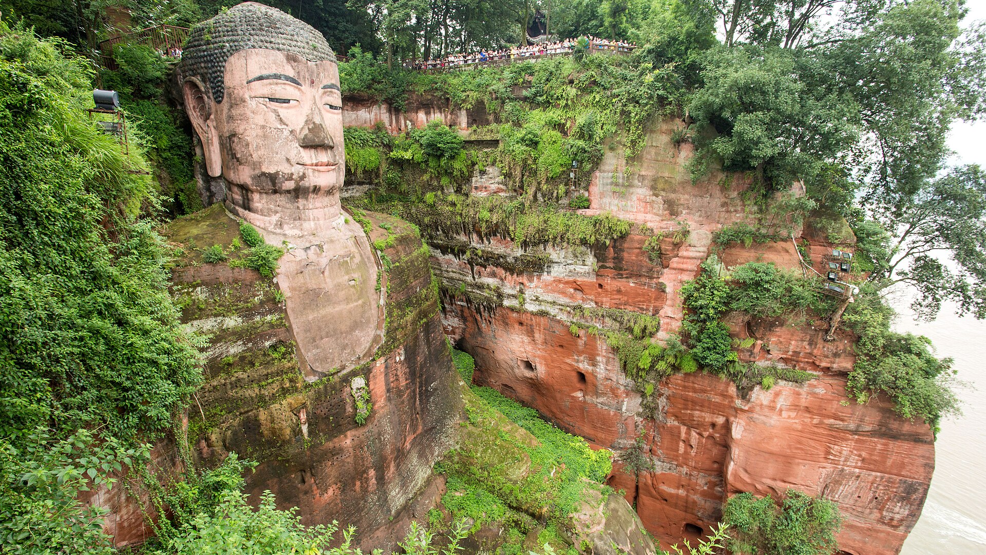 A colossal stone Buddha, itself a cliff