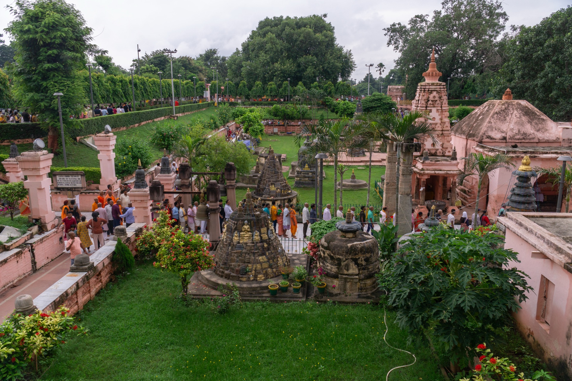 Votive stupas ringing the great tower, pilgrims walking the grounds