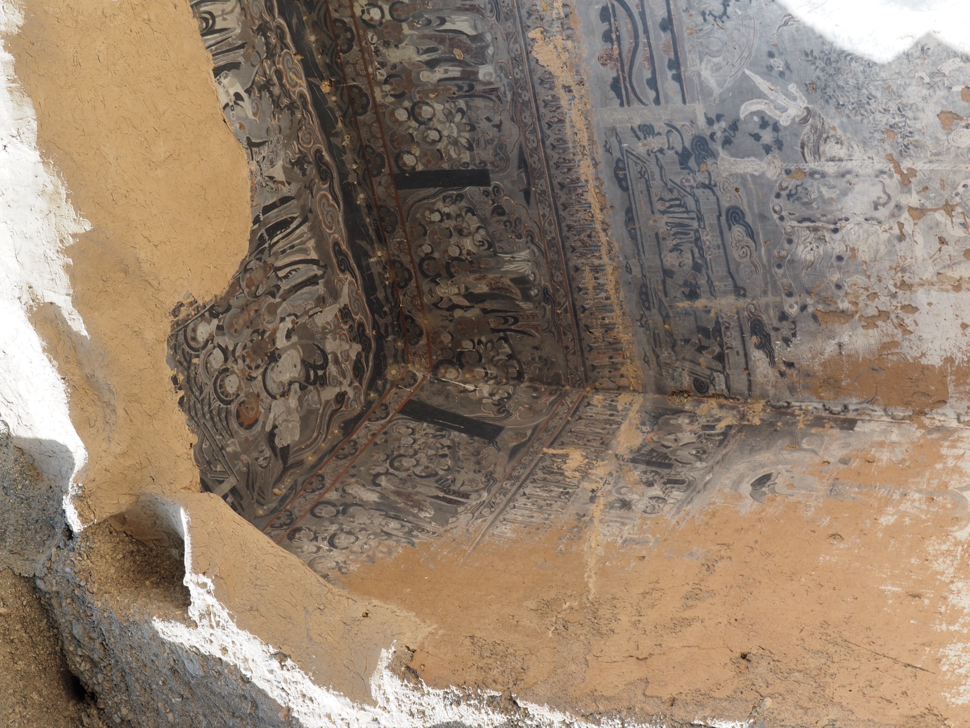 Walls and ceiling of a Mogao cave covered with Buddhas and stories in paint