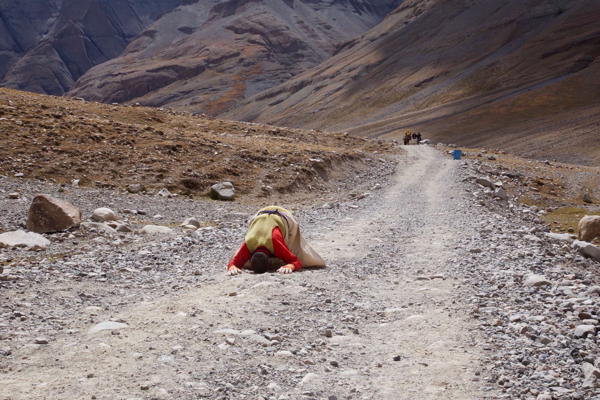 A pilgrim prostrating full-length along the kora path around Kailash