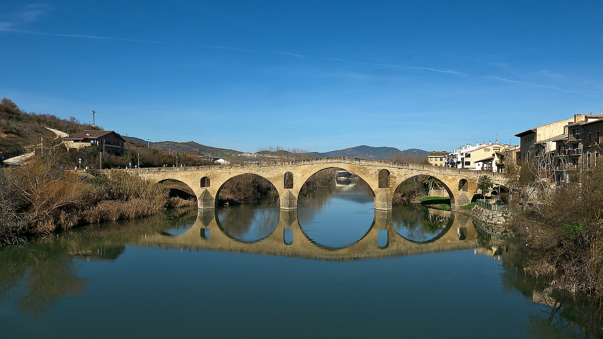 The six-arched pilgrim bridge reflected in the River Arga