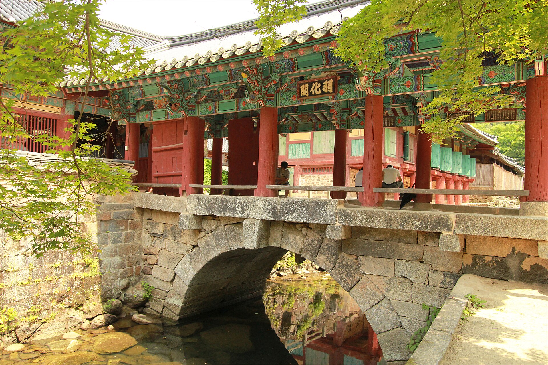 The Uhwagak covered bridge resting on a stone arch over the stream