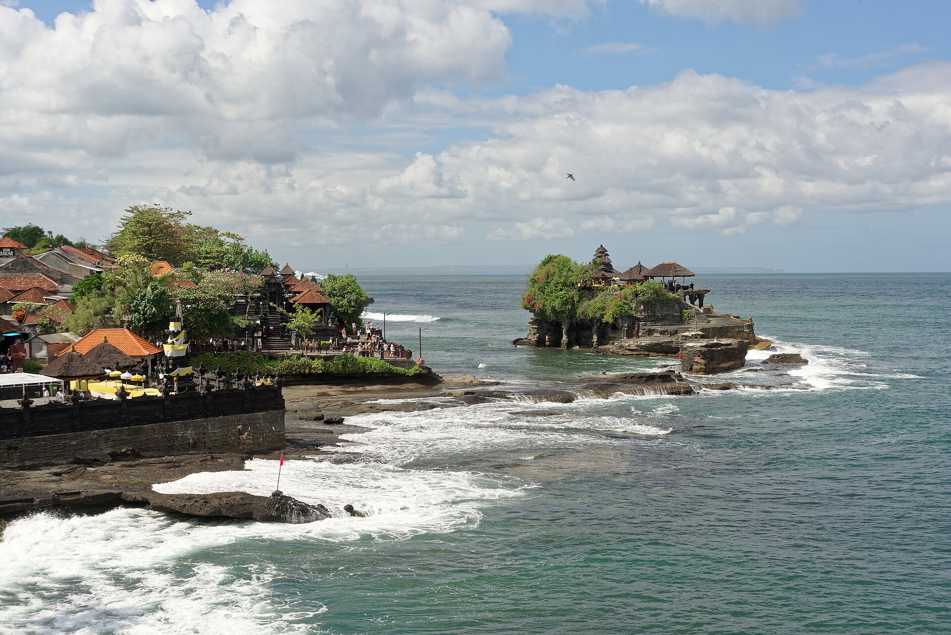 The temple and its rock along the surf-lined shore