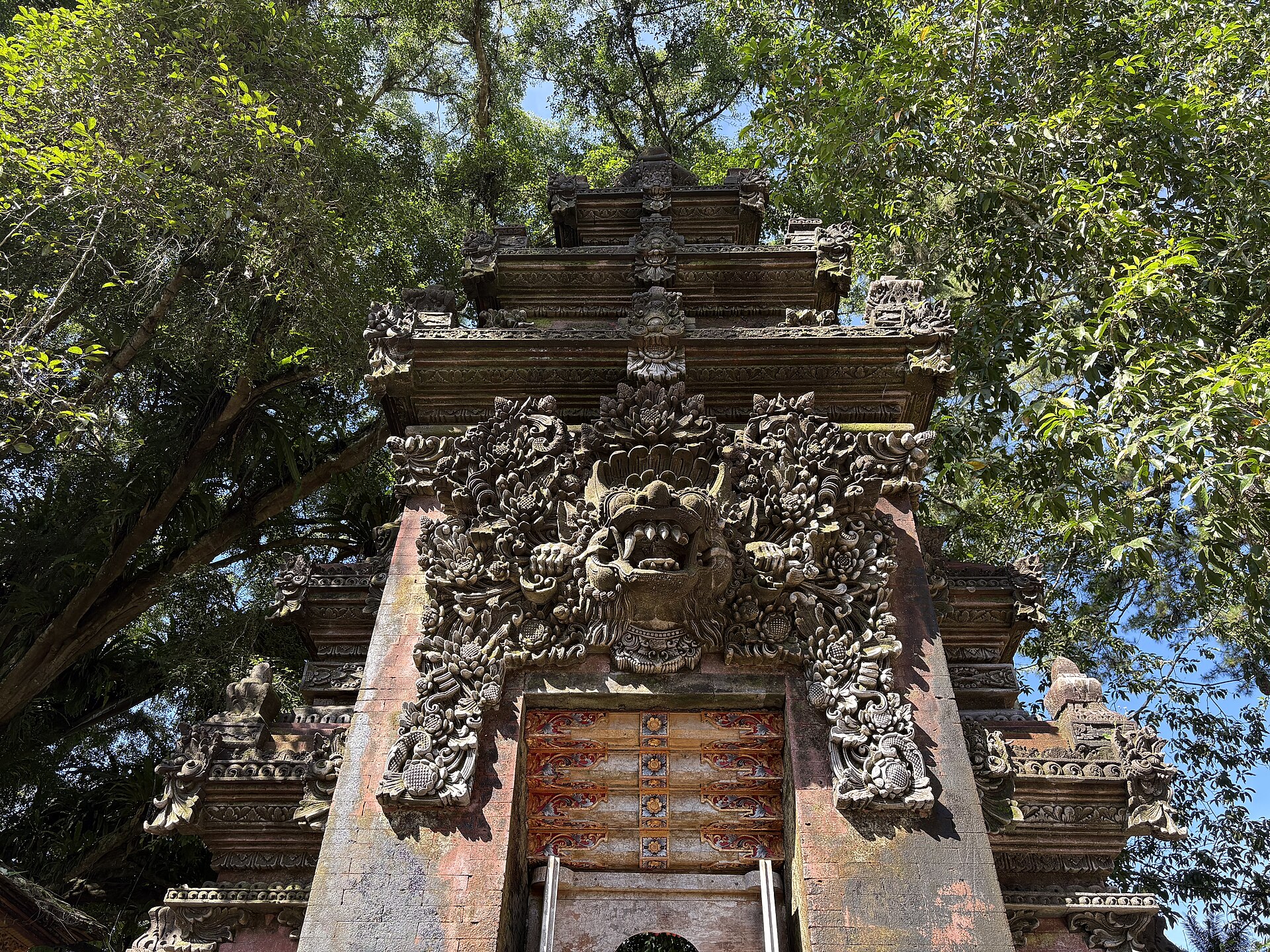 An intricately carved temple gateway among the trees