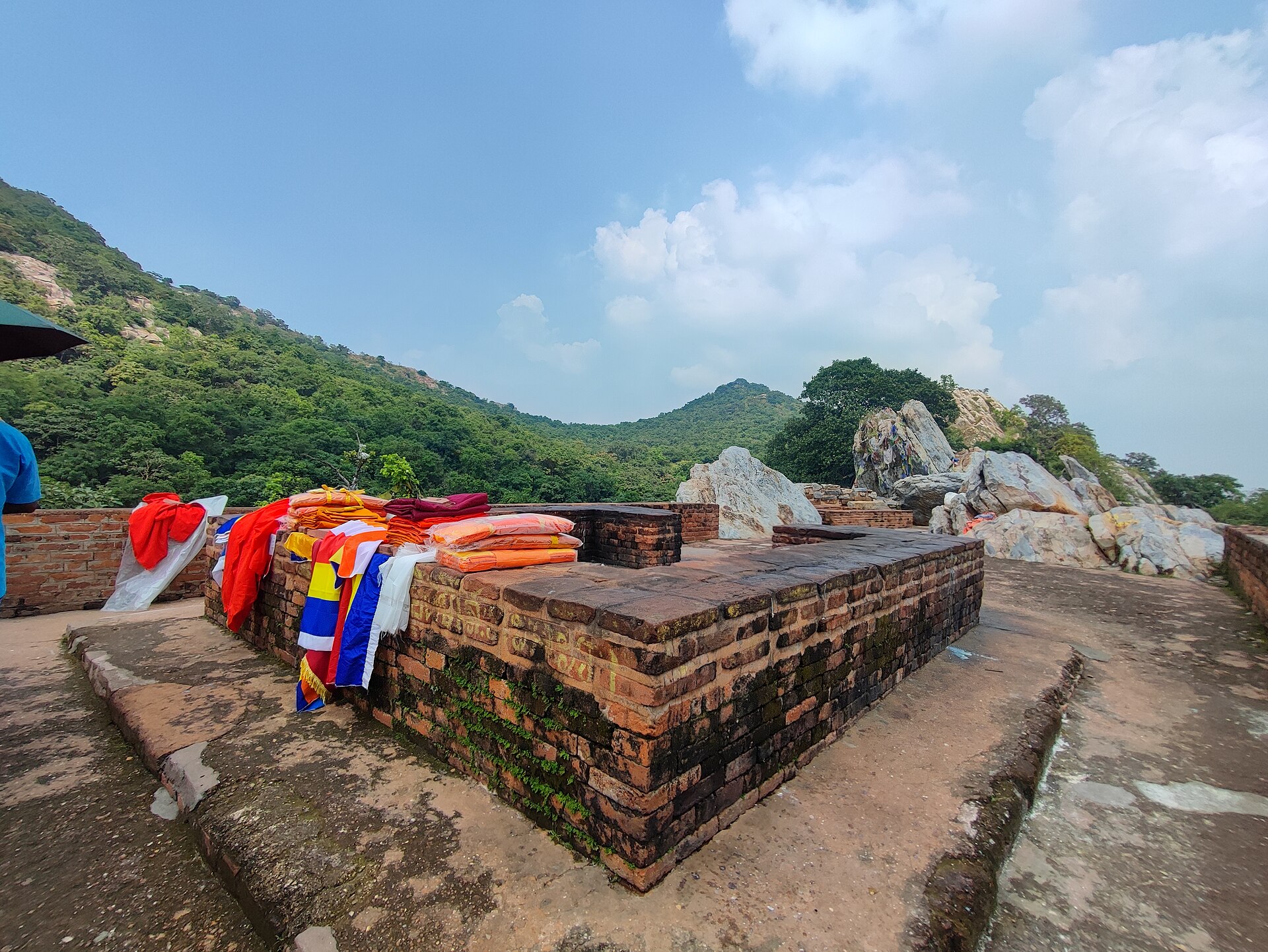 Prayer flags draped over the summit rocks above the green valley