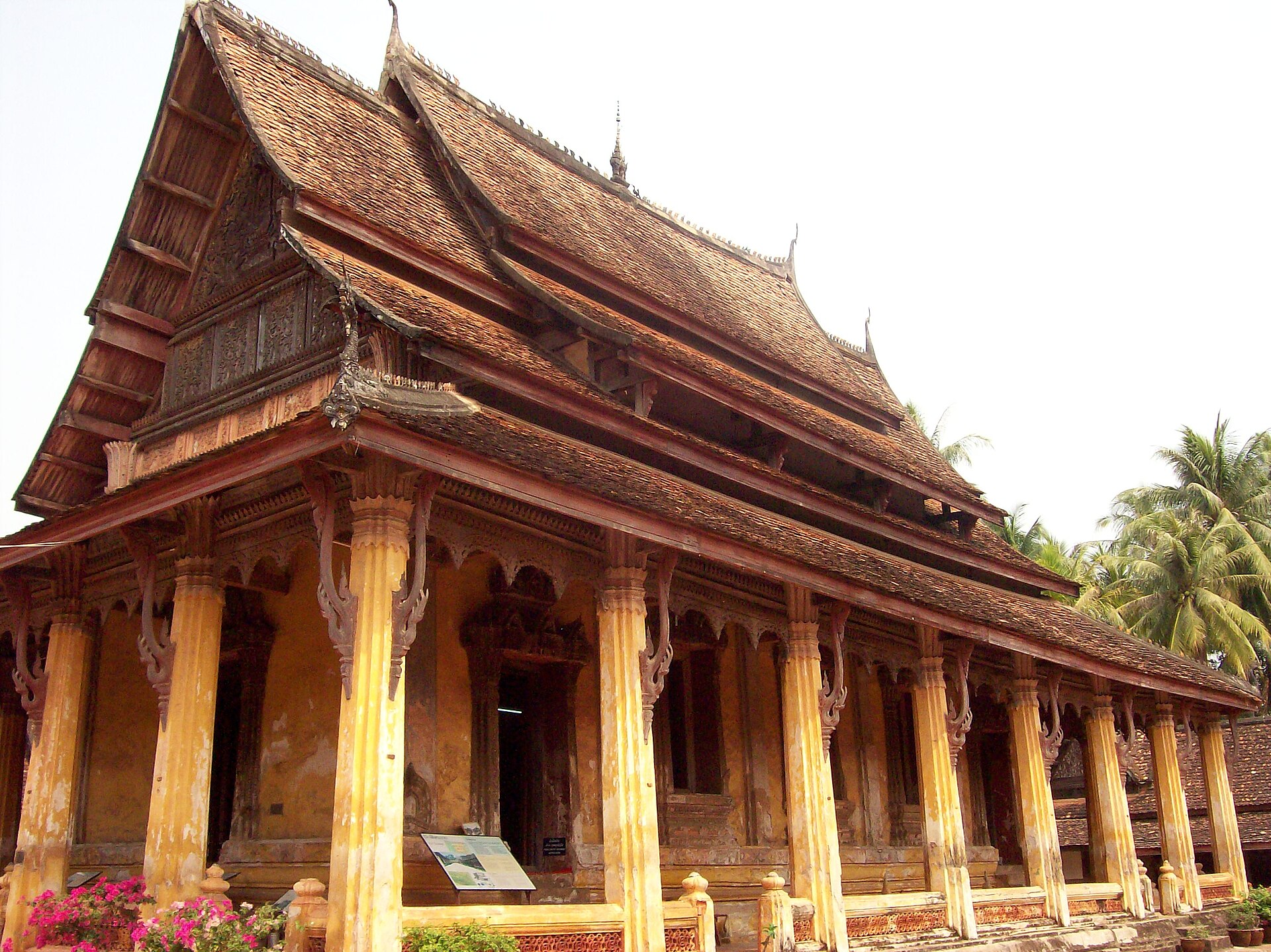 The layered roofs and wooden eaves of Wat Si Saket seen from below