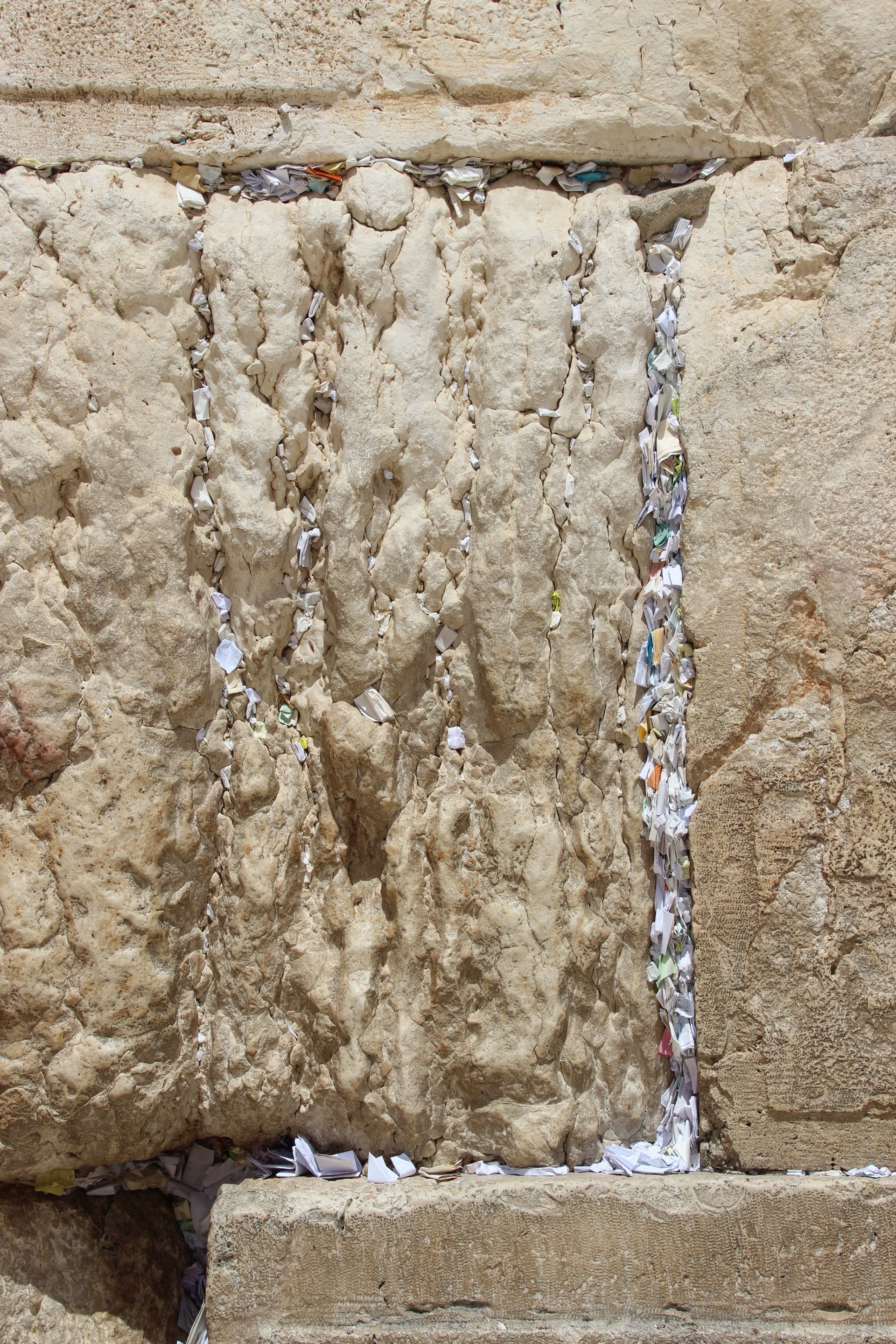 Folded prayer notes packed into every crack of the Western Wall's stones