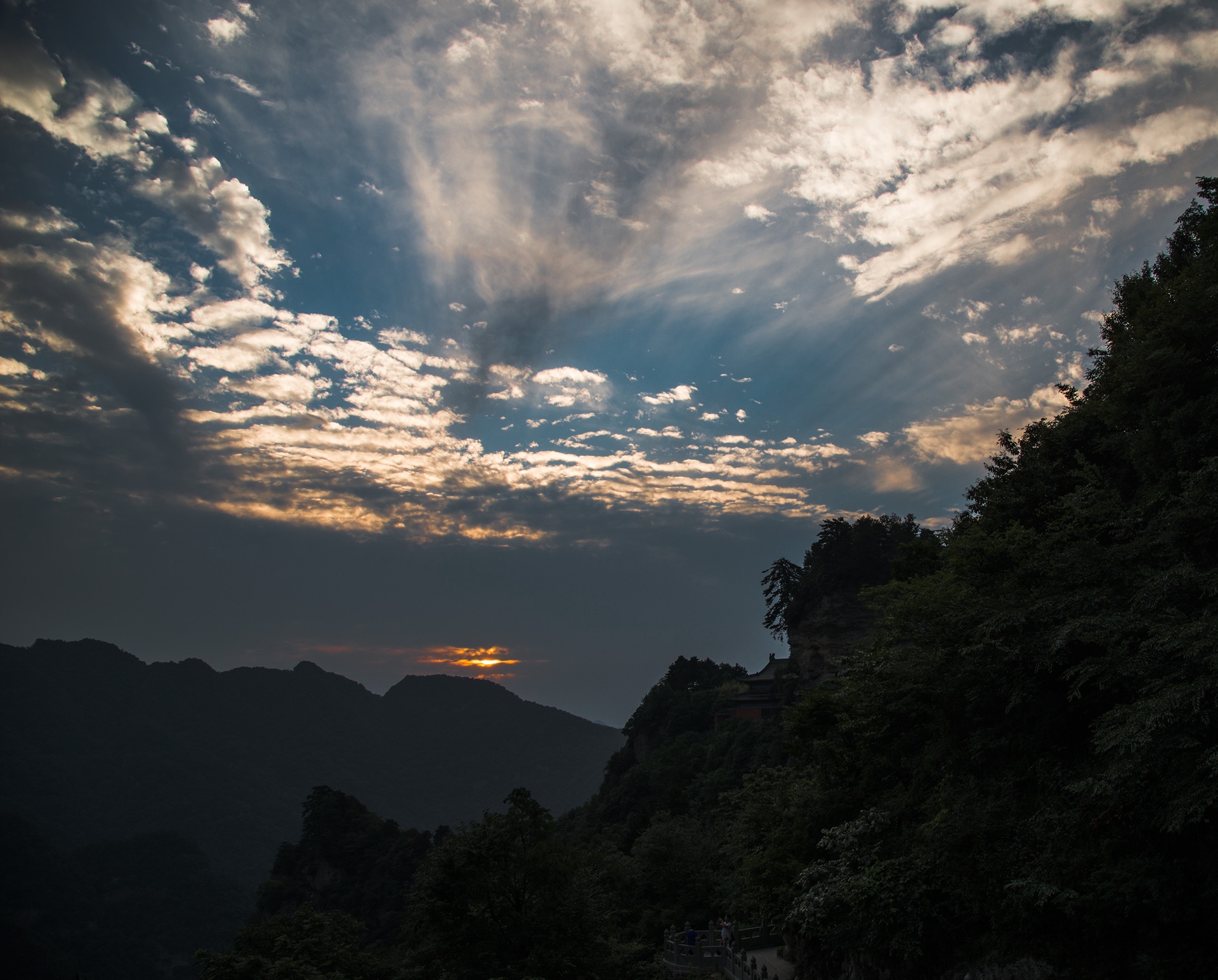 The sun setting beyond the cloud-wrapped peaks of Wudang