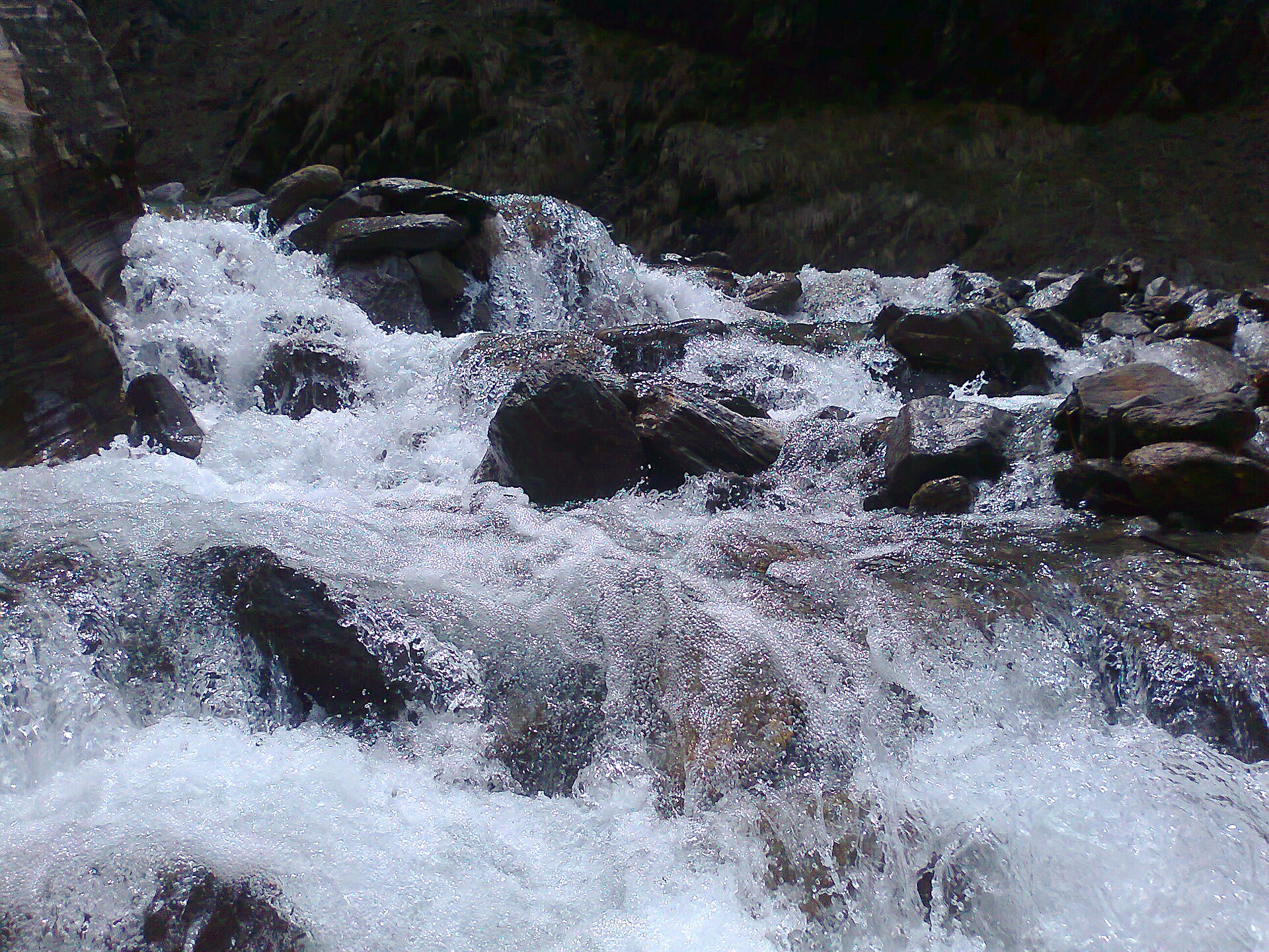 The milky Yamuna newly born, crashing over the rocks